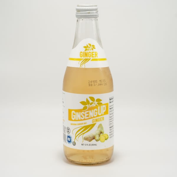 A bottle of Ginseng Up Natural Ginger Ale with a white and yellow label on a white background.
