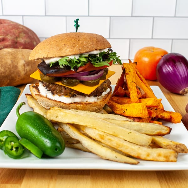 FoodAMed's healthy burger with cheese, lettuce, tomato, onion, and jalapeños, served with fries.
