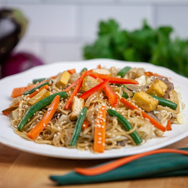 FoodAMed's healthy stir-fried noodles with tofu, carrots, green beans, and red bell peppers.