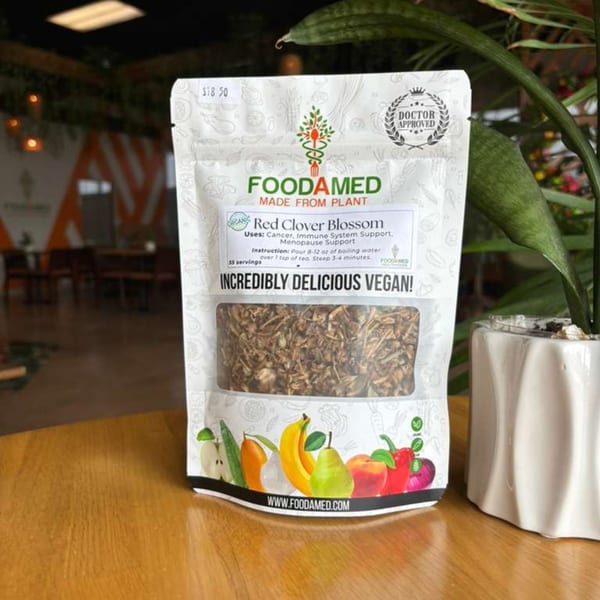 Foodamed Red Clover Blossom tea bag on a wooden table next to a potted plant.