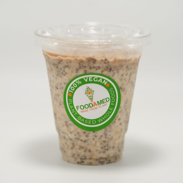 A clear plastic cup of Foodamed vegan chia pudding with a green label on a white background.