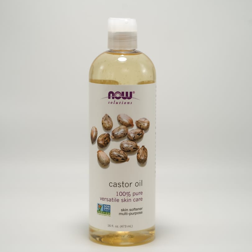 A bottle of Now Solutions 100% pure castor oil for versatile skin care.