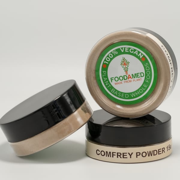 Three small jars of Foodamed Comfrey Powder, one with a green "100% Vegan" label, stacked on a white surface.