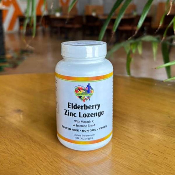 A white bottle of Elderberry Zinc Lozenges with Vitamin C and Immune Blend on a wooden table.