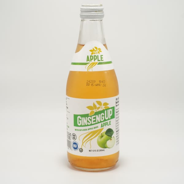 A bottle of Ginseng Up Apple juice with a white label and green apple graphic.