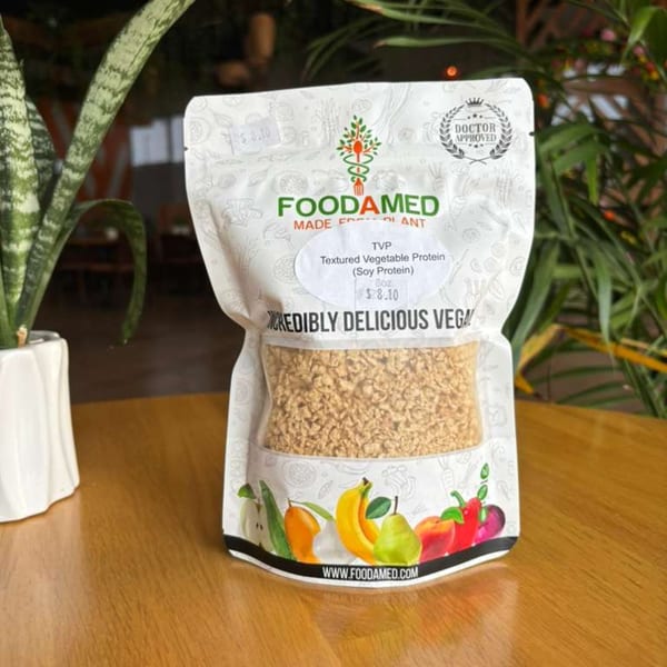 Foodamed TVP (Textured Vegetable Protein) package on a wooden table next to a potted plant.