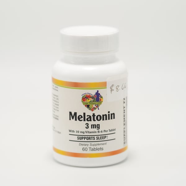 A white bottle of Melatonin 3 mg dietary supplement with a Cooper Wellness Center label.