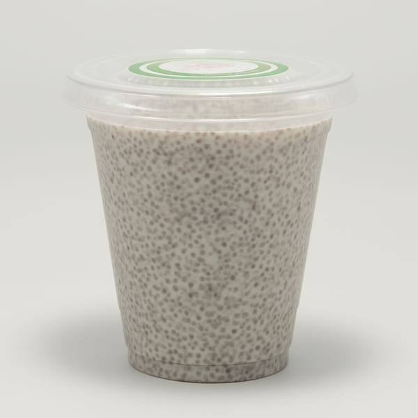 A clear plastic cup filled with chia seed pudding, topped with a clear lid and green sticker.
