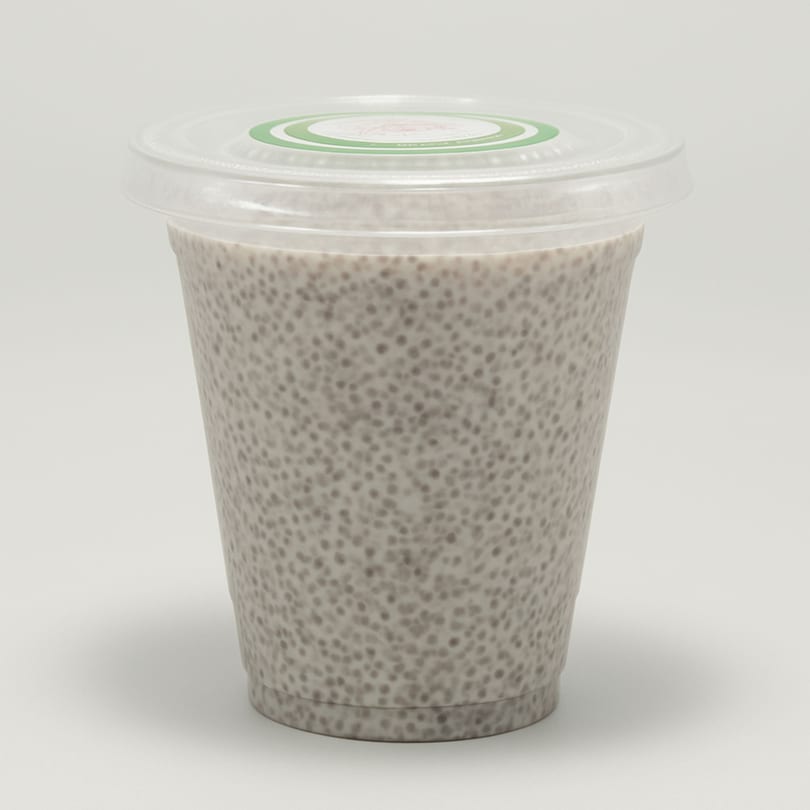 A clear plastic cup filled with chia seed pudding, topped with a clear lid and green sticker.